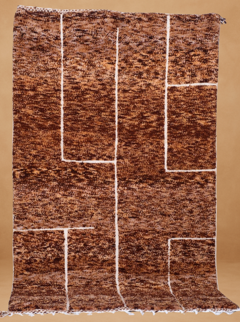 Beni Ouarain rug with a richly textured brown and copper-toned background, intersected by bold white linear shapes forming a minimalist, modern grid pattern. Handwoven in wool, the rug is displayed vertically with fringed edges, set against a neutral beige backdrop.