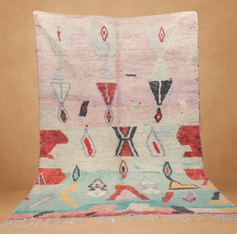 Soft Boujad rug with pastel pink and mint tones, accented by bold red and black tribal patterns.