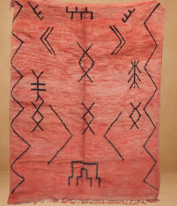 Elegant Boujad rug in warm coral tones with minimalist black geometric patterns.