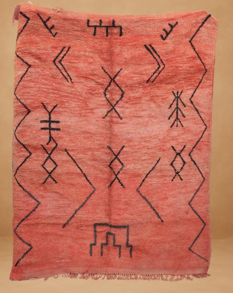 Elegant Boujad rug in warm coral tones with minimalist black geometric patterns.