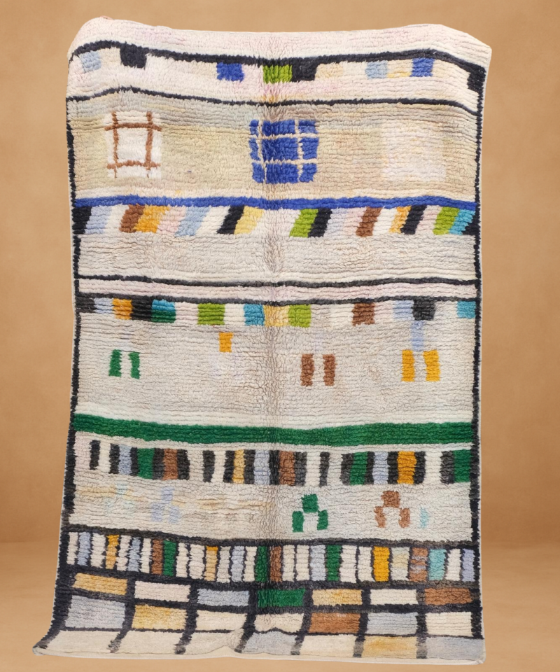 Modern Boujad rug with colorful abstract blocks and lines on a cream base.
