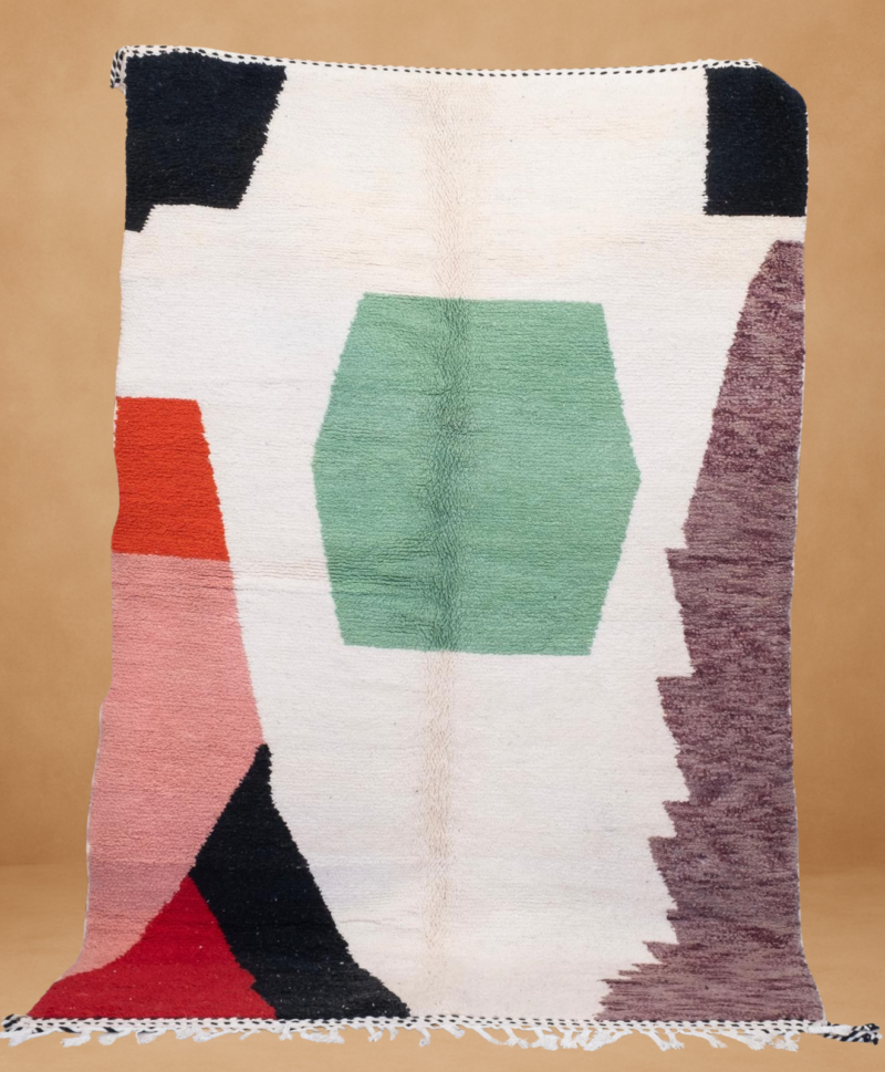 Modern Boujad rug with bold geometric shapes in green, red, black, and cream tones.