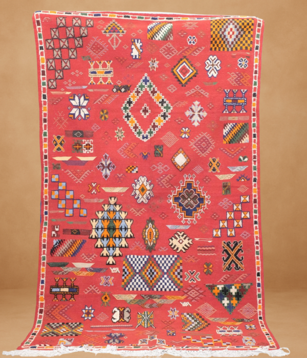 Vivid Kilim rug in ruby red, featuring intricate tribal symbols and geometric shapes. Lightweight and flatwoven.
