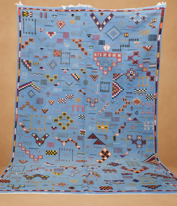 Vibrant Kilim rug with a stunning blue backdrop, adorned with colorful tribal patterns and geometric motifs.