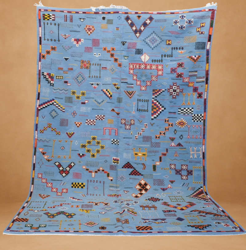 Vibrant Kilim rug with a stunning blue backdrop, adorned with colorful tribal patterns and geometric motifs.